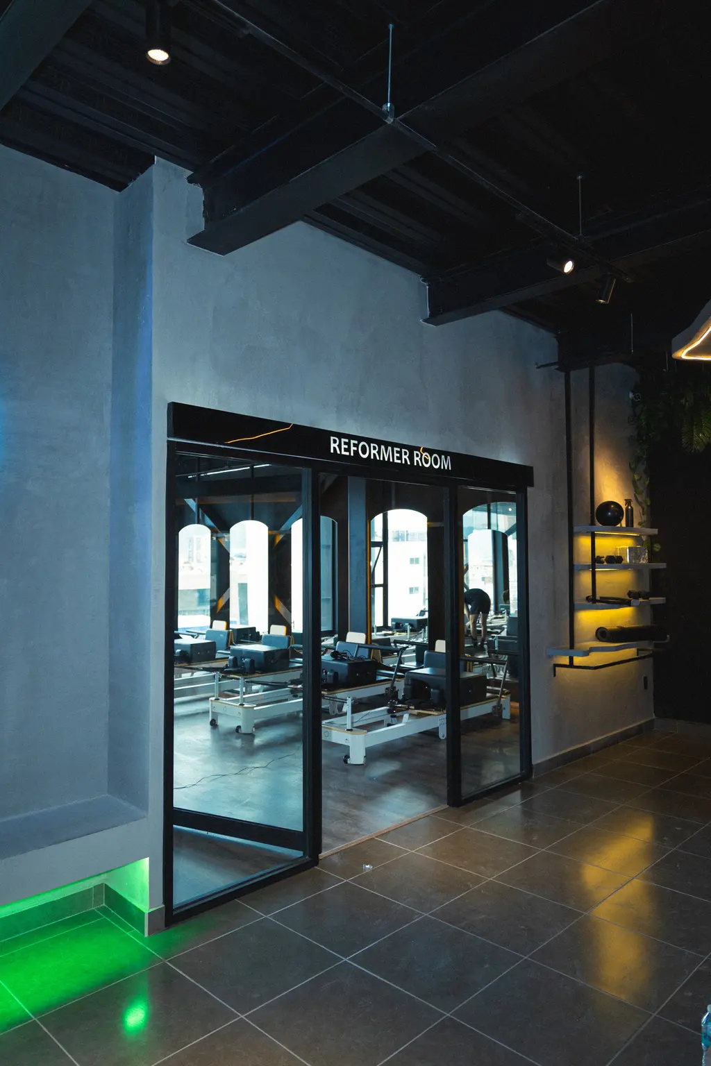 Acceso de cristal a la Reformer Room con la señalética REFORMER ROOM